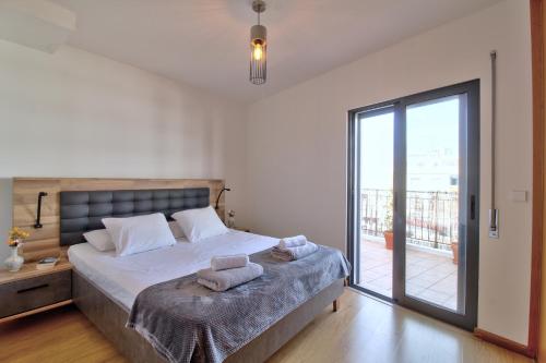 1 dormitorio con 1 cama con toallas en Spacious terrace, swimming pool, private parking en Olhão