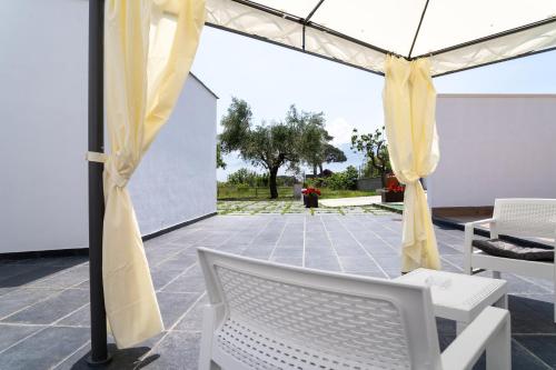 a patio with a white chair and an umbrella at Napul'è B&B in Boscotrecase