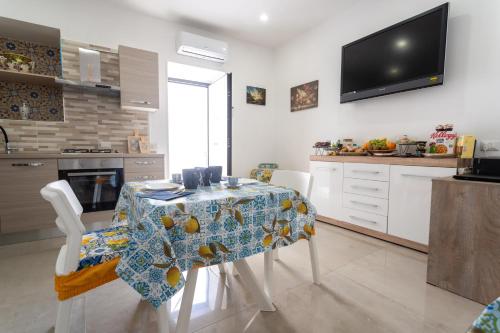 a kitchen with a table and chairs and a television at Napul'è B&B in Boscotrecase