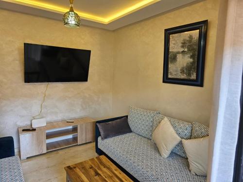 a living room with a couch and a flat screen tv at Appartement de rêve 2 in Marrakech