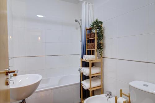 a bathroom with a sink and a toilet and a shower at Spacious terrace, swimming pool, private parking in Olhão