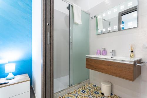 y baño con ducha y lavamanos. en Napul'è B&B, en Boscotrecase
