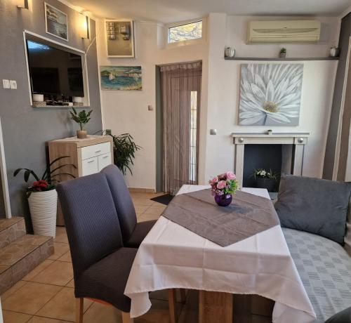 ein Wohnzimmer mit einem Tisch, Stühlen und einem Kamin in der Unterkunft Apartment Ana Lozica with terrace in Dubrovnik