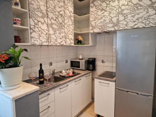 eine Küche mit weißen Schränken und einem Kühlschrank in der Unterkunft Apartment Ana Lozica with terrace in Dubrovnik