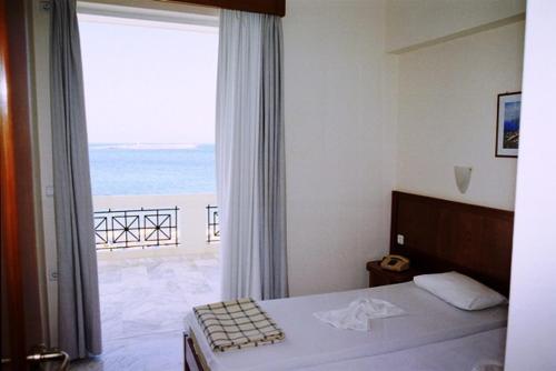 a bedroom with a bed with a view of the ocean at Nea Elena Apartments in Chania