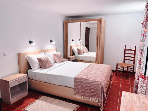 una camera con un grande letto e uno specchio di Apartamentos Quinta Mae dos Homens a Funchal