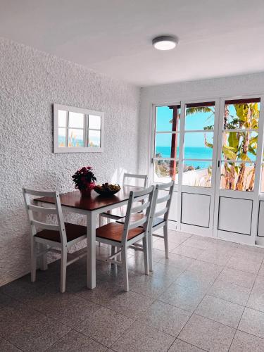 a dining room with a table and chairs and the ocean at Apartamentos Quinta Mae dos Homens in Funchal