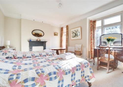 um quarto com uma cama, uma secretária e um piano em The Edwardian House em Ilfracombe