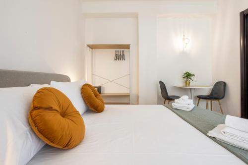 a bedroom with a large white bed with orange pillows at Re di Roma - Charme Apartment in Rome