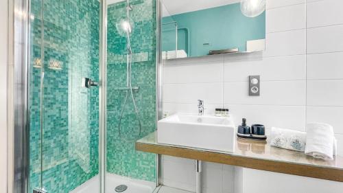 a bathroom with a sink and a glass shower at HOMEY AWESOME - Proche Gare et Tram - Centre-ville - Balcon privé - Wifi gratuit in Annemasse