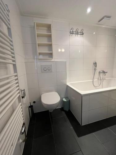 La salle de bains blanche est pourvue de toilettes et d'un lavabo. dans l'établissement Appartementen het Centrum, à Domburg