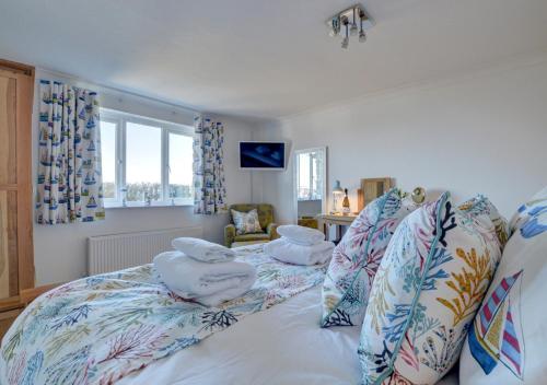 a bedroom with a bed with pillows on it at Farthings Nest in Ilfracombe