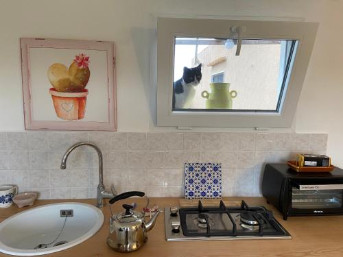 a kitchen counter with a stove and a window at Rifugio tra gli ulivi in Marina di Ragusa