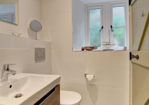 a bathroom with a sink and a toilet and a window at Fox Cottage in Lynmouth