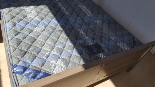 a bed with blue and white sheets on it at Room near Sheba Medical Center, and Bar Ilan, and TLV Airport in Qiryat Ono