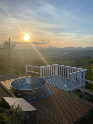 a hot tub sitting on a deck with the sunset at B&B L'OFFICINA DEI SOGNI in Poggio Morello