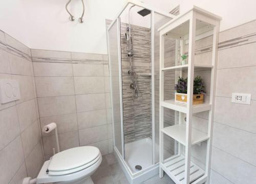 uma casa de banho branca com um WC e um chuveiro em Alloggio Turistico Flavia em Anzio
