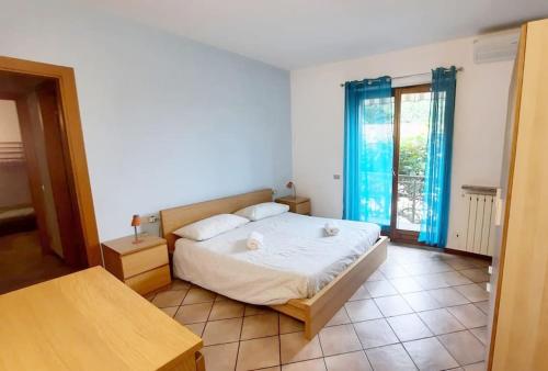 1 dormitorio con 1 cama grande y cortinas azules en Il Vecchio Kiwi - House with private garden, en Oleggio Castello