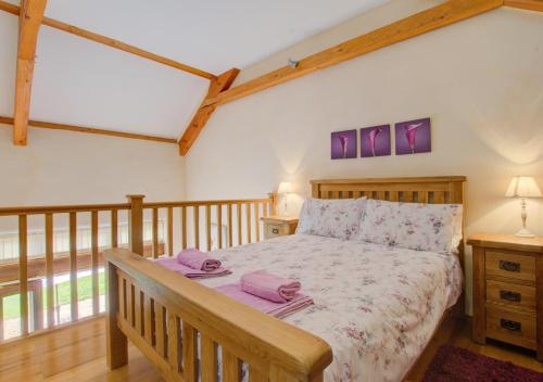 a bedroom with a wooden bed with purple sheets at The Gearing in Bampton