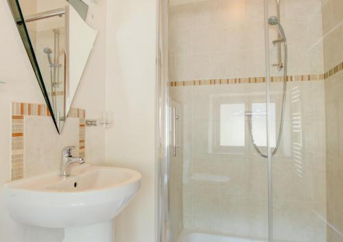 a white bathroom with a sink and a shower at The Gearing in Bampton