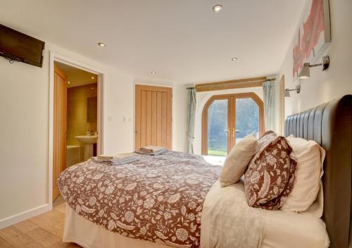 a bedroom with a bed and a couch and a window at The Granary Muddiford in Shirwell