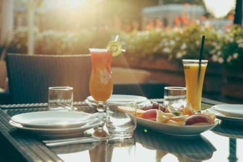 a table with a bowl of fruit and two drinks at Tskaltubo Plaza Hotel in Tskaltubo