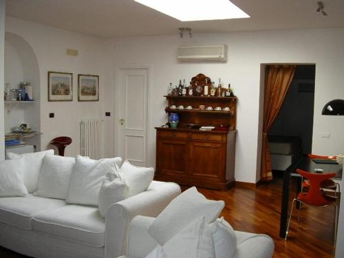 a living room with a white couch and a piano at Tavernola - Locanda Di Campagna in Battipaglia