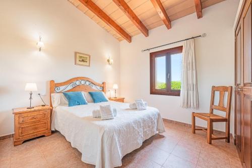 1 dormitorio con cama, ventana y silla en Ca Na Neus, en Pollensa