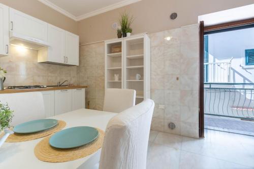 Una cocina y un comedor con mesa y sillas. en Appartamento Il Belvedere - MyHo Casa, en Vieste