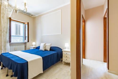 Un dormitorio con una cama azul y blanca y una ventana. en Appartamento Il Belvedere - MyHo Casa, en Vieste