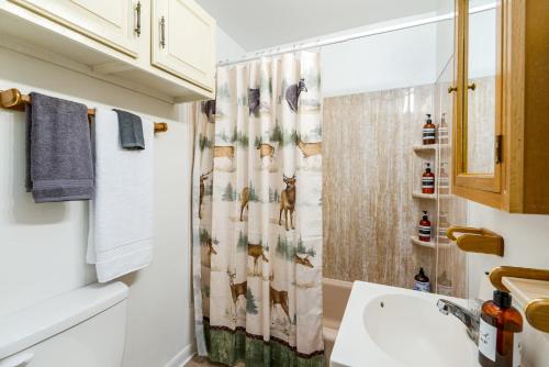 a bathroom with a shower curtain with animals on it at River Access Cabin- WiFi, Huge Deck&Grill, Hot tub in Luray