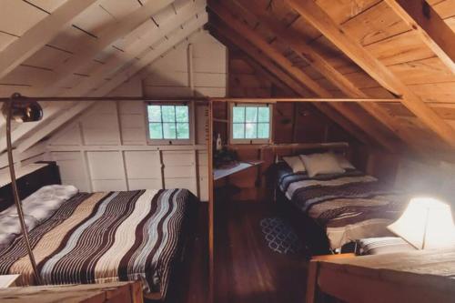 1 dormitorio con 2 camas en un ático en Grant Island Waterfront Cottage Brantingham Lk - Dogs Love - Worlds Raddest Island, en Glenfield