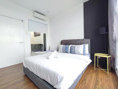 a bedroom with a large white bed and a yellow stool at Family-Friendly 2BR Apartment , Cozy Room near MITEC Malaysia , Arte Mont Kiara in Kuala Lumpur