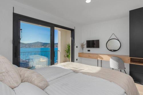a bedroom with a bed and a desk and a window at Seafront villa with roofpool, perfect getaway in Vinišće