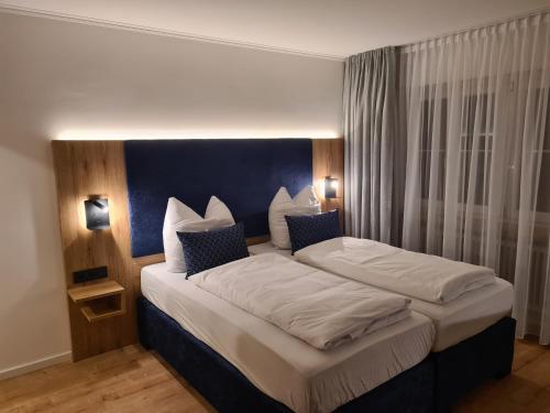 a bedroom with a large bed with a blue headboard at Raffelsteiner Hof in Mörnsheim