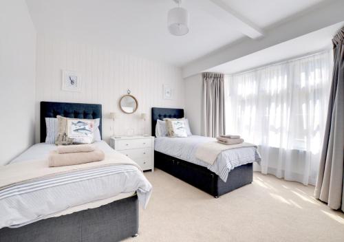 a bedroom with two beds and a window at Harbour View Lynmouth in Lynmouth