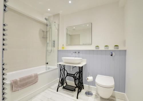 a white bathroom with a sink and a toilet at Harbour View Lynmouth in Lynmouth