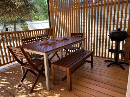 a wooden table and chairs on a deck with a grill at Happy Home in Biograd na Moru