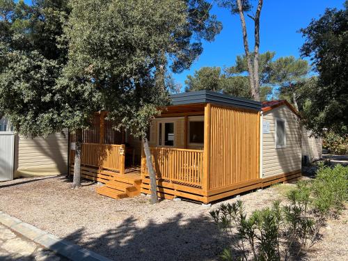 a wooden cabin with a deck in a yard at Happy Home in Biograd na Moru