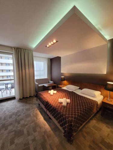 1 dormitorio con 1 cama grande y 2 toallas. en Diva Resort en Kołobrzeg