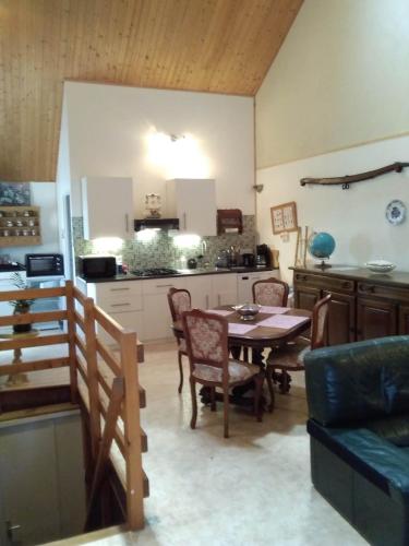 a kitchen and dining room with a table and chairs at Hirondelles et mésanges in Fromental