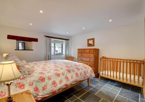 a bedroom with a bed and a crib at Hawthorn Cottage in Barbrook