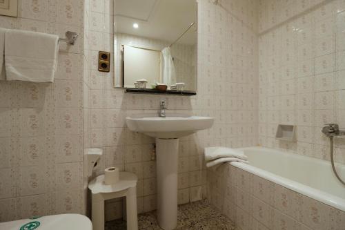 a bathroom with a sink and a toilet and a bath tub at Hotel Delavall in Vielha