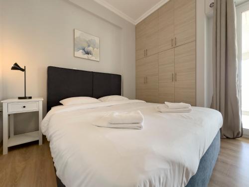 ein Schlafzimmer mit einem großen weißen Bett mit zwei Handtüchern darauf in der Unterkunft Iakovaton Modern 62sqm in Athens in Athen