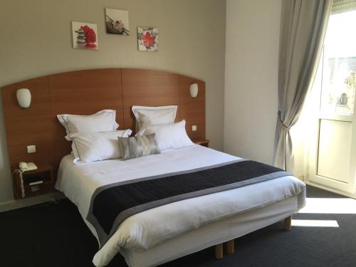 梅斯的住宿－Alerion Centre Gare，一间卧室配有一张大床和木制床头板
