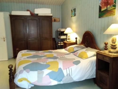 Hirondelles et mésanges في Fromental: غرفة نوم مع سرير مع لحاف ملون