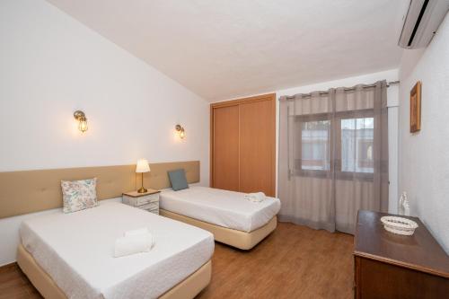 ein Hotelzimmer mit 2 Betten und einem Fenster in der Unterkunft Vivenda Solar dos Pescadores in Armação de Pêra