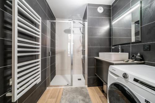 une salle de bain avec douche et machine à laver dans l'établissement Kotibé Chamonix - BY EMERALD STAY, à Chamonix-Mont-Blanc
