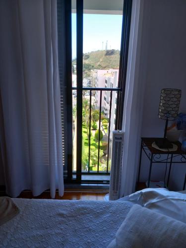 a bedroom with a bed and a window with a view at Efd Varzea Park in Funchal