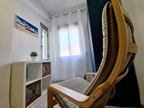 a rocking chair in a room with a window at Comfy Apartment With a Castle View in Cullera